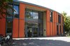 Außenansicht einer Berliner Selbsthilfe-Kontaktstelle: orangefarbenes Gebäude mitGlasfassade